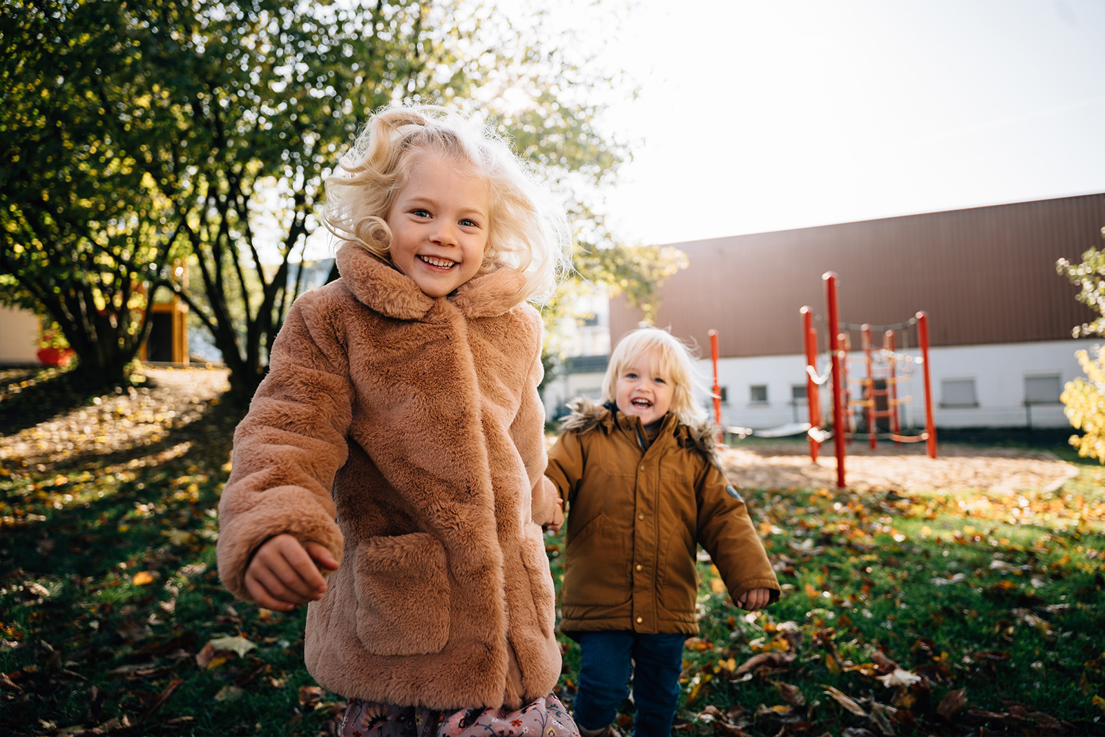 Zwei Kinder laufen im Kindergarten und lachen - Kitafotograf Frankenberg